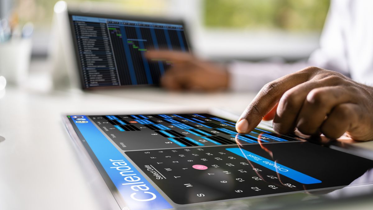 Hand tapping a calendar app on a tablet screen