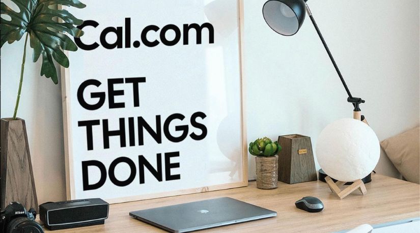 Desk with laptop and Cal.com Get Things Done poster