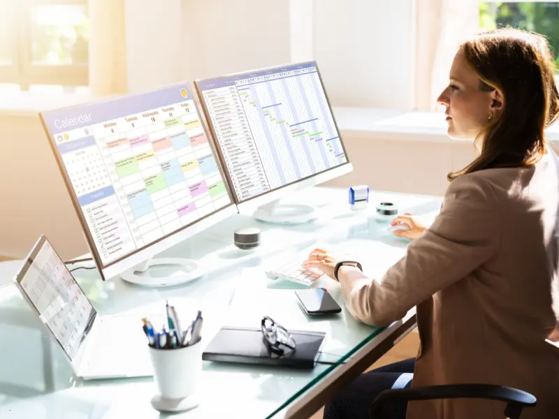 Meeting scheduling tips shown on dual monitors with a color-coded calendar and timeline chart.