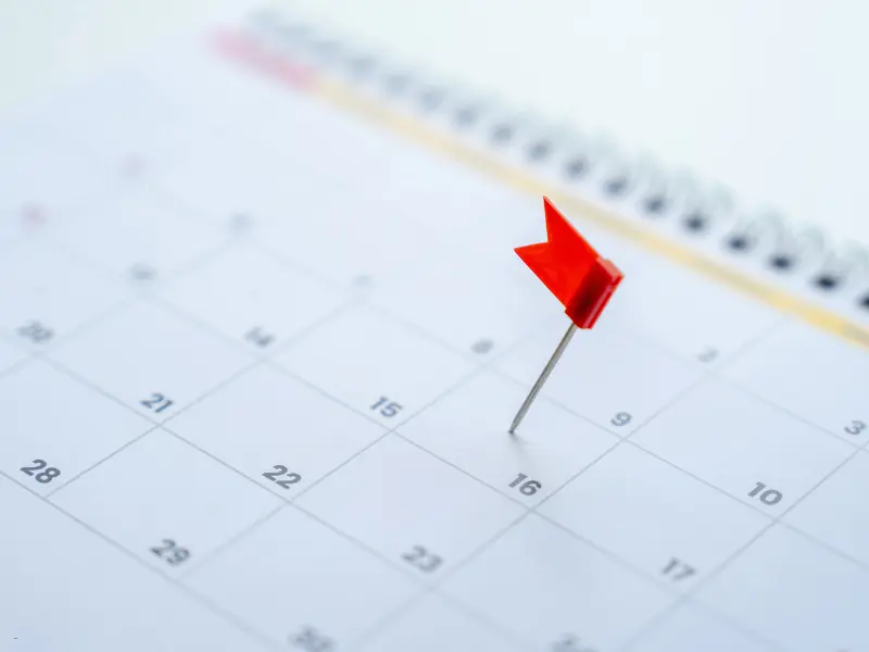Best digital calendars help users stay organized, as shown by a red flag marking a date on a paper planner.