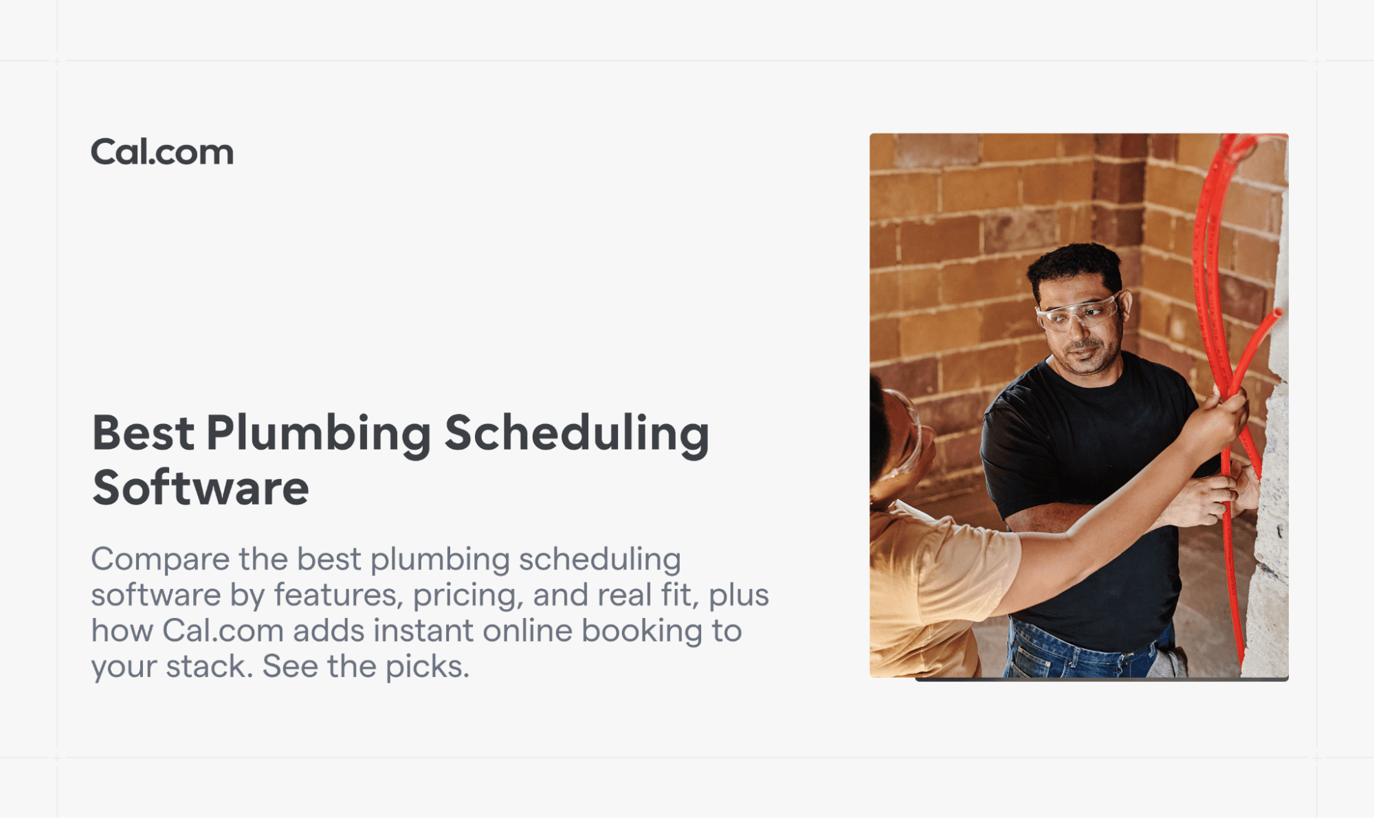 Plumbers working with red tubing against a brick wall