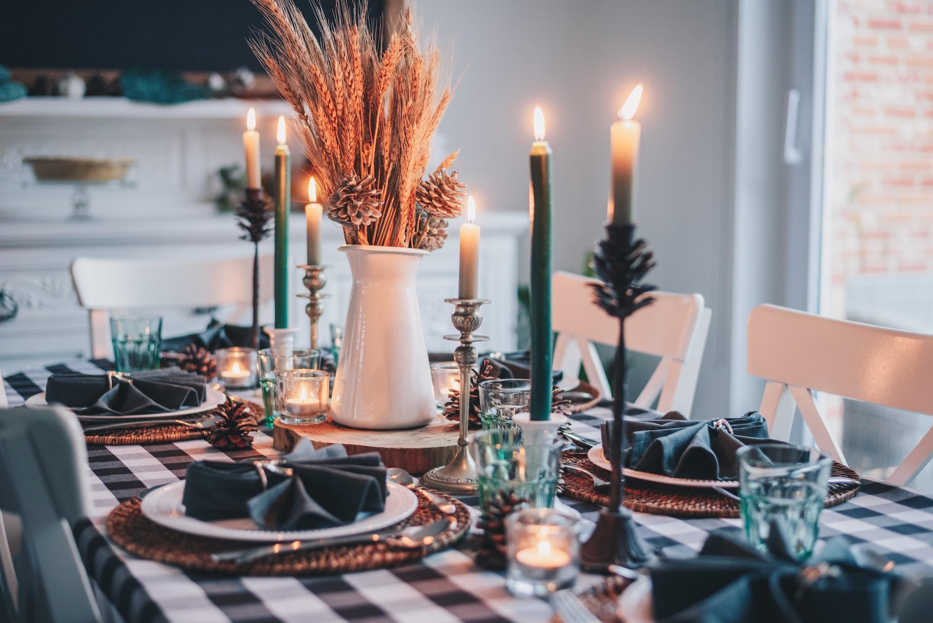 Holiday dinner table set with candles and greenery