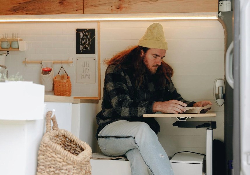 Man working on a laptop inside a camper van