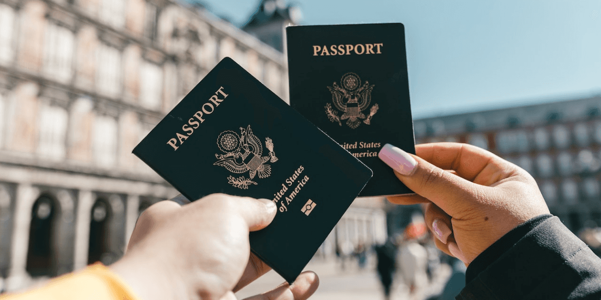 Two hands holding US passports outdoors