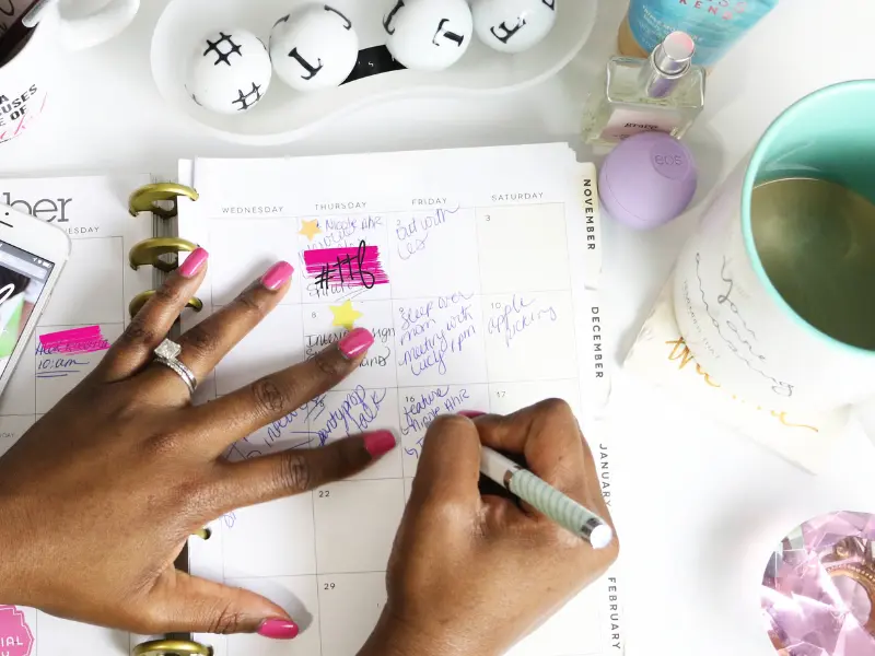 Smart appointment scheduling with a decorated planner, as a person organizes tasks using handwritten notes and colorful highlights.