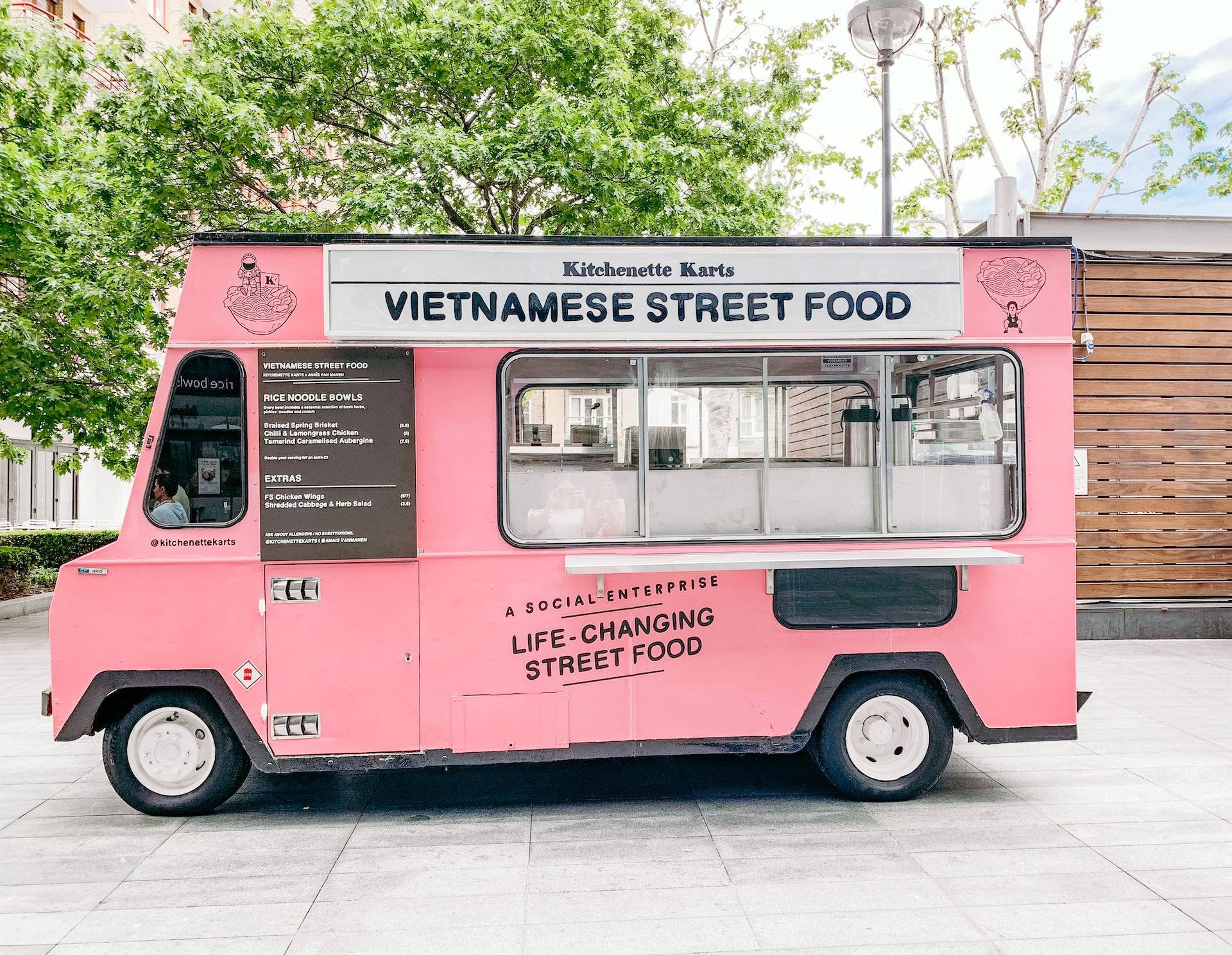 Pink Vietnamese street food truck parked outside