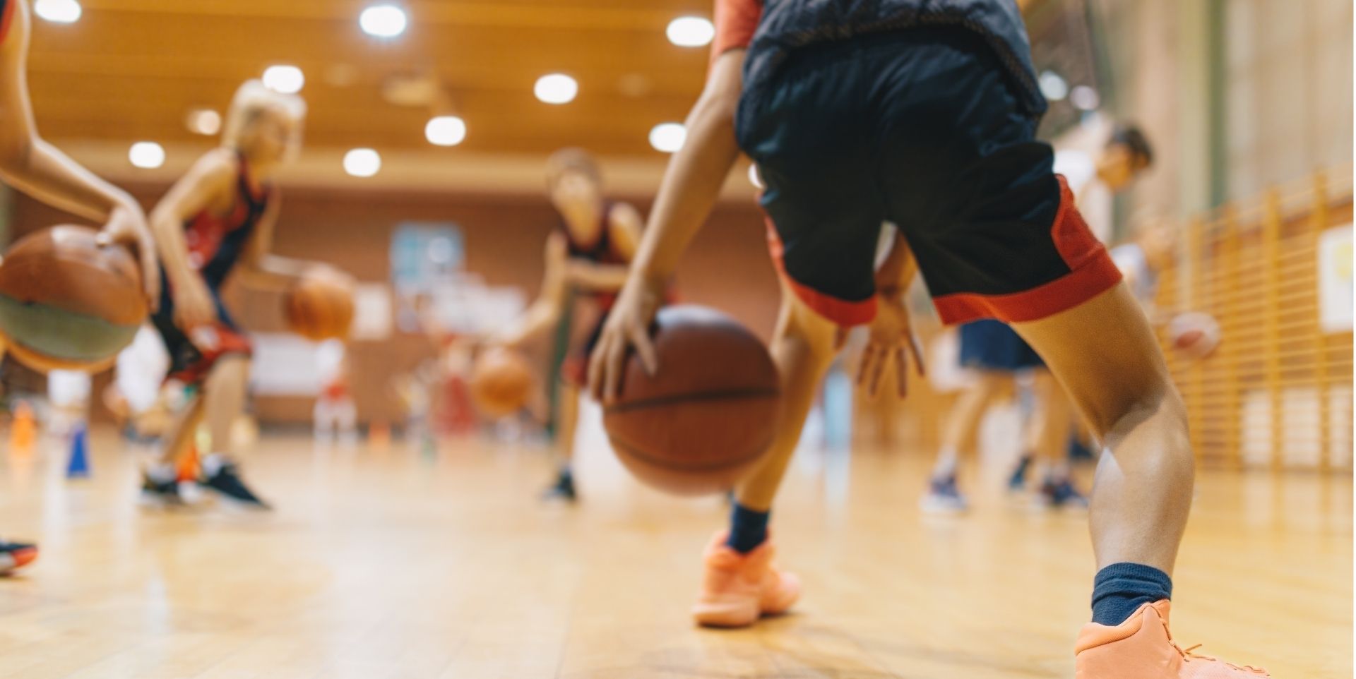 Basketball players dribbling on an indoor court