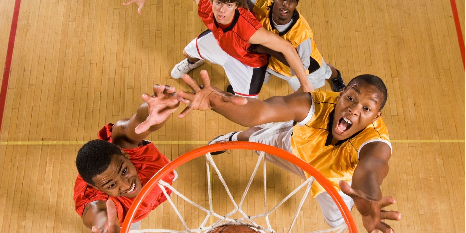 Basketball players competing for a dunk at the hoop