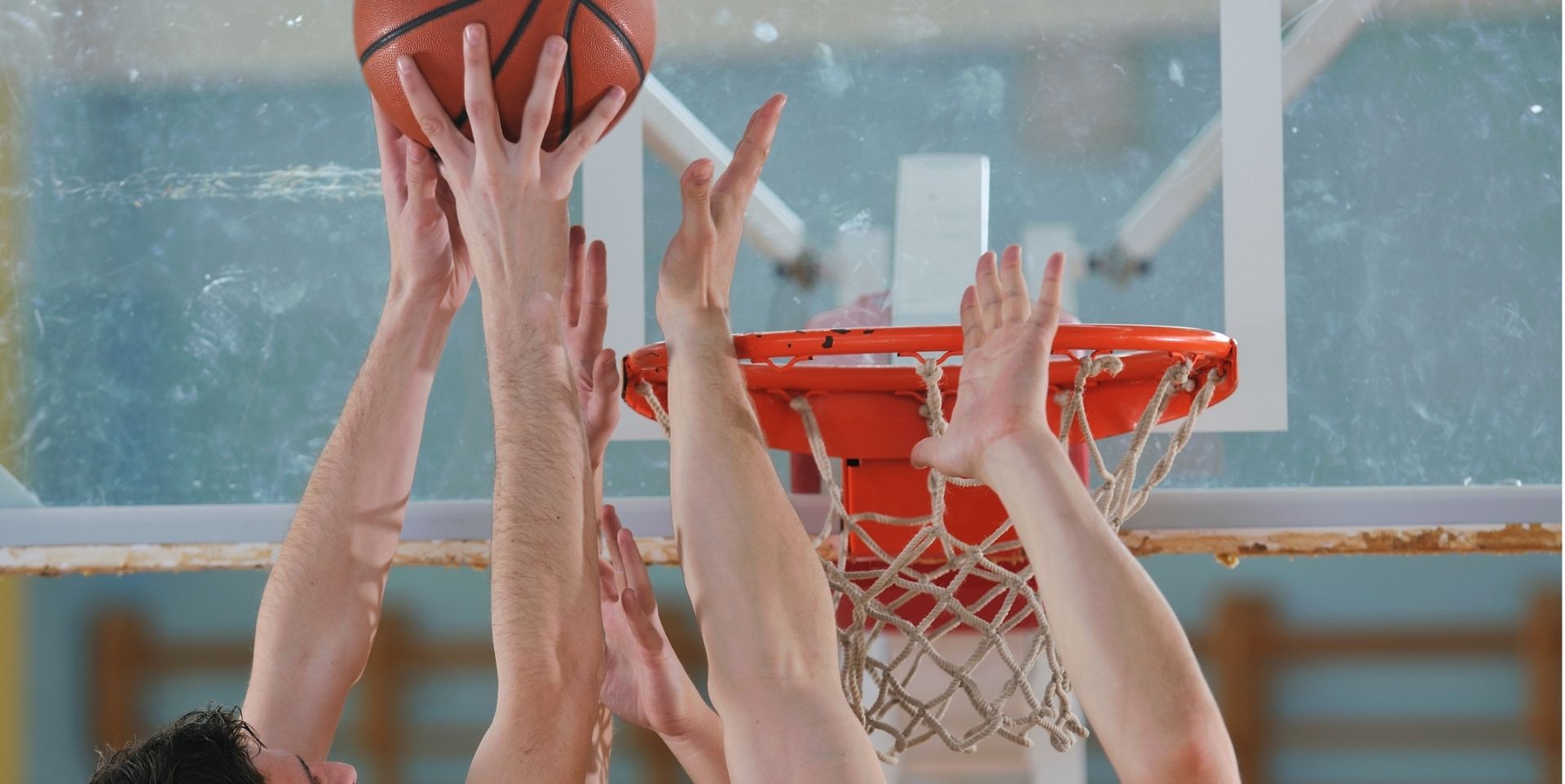 Basketball players jumping for a rebound near the hoop