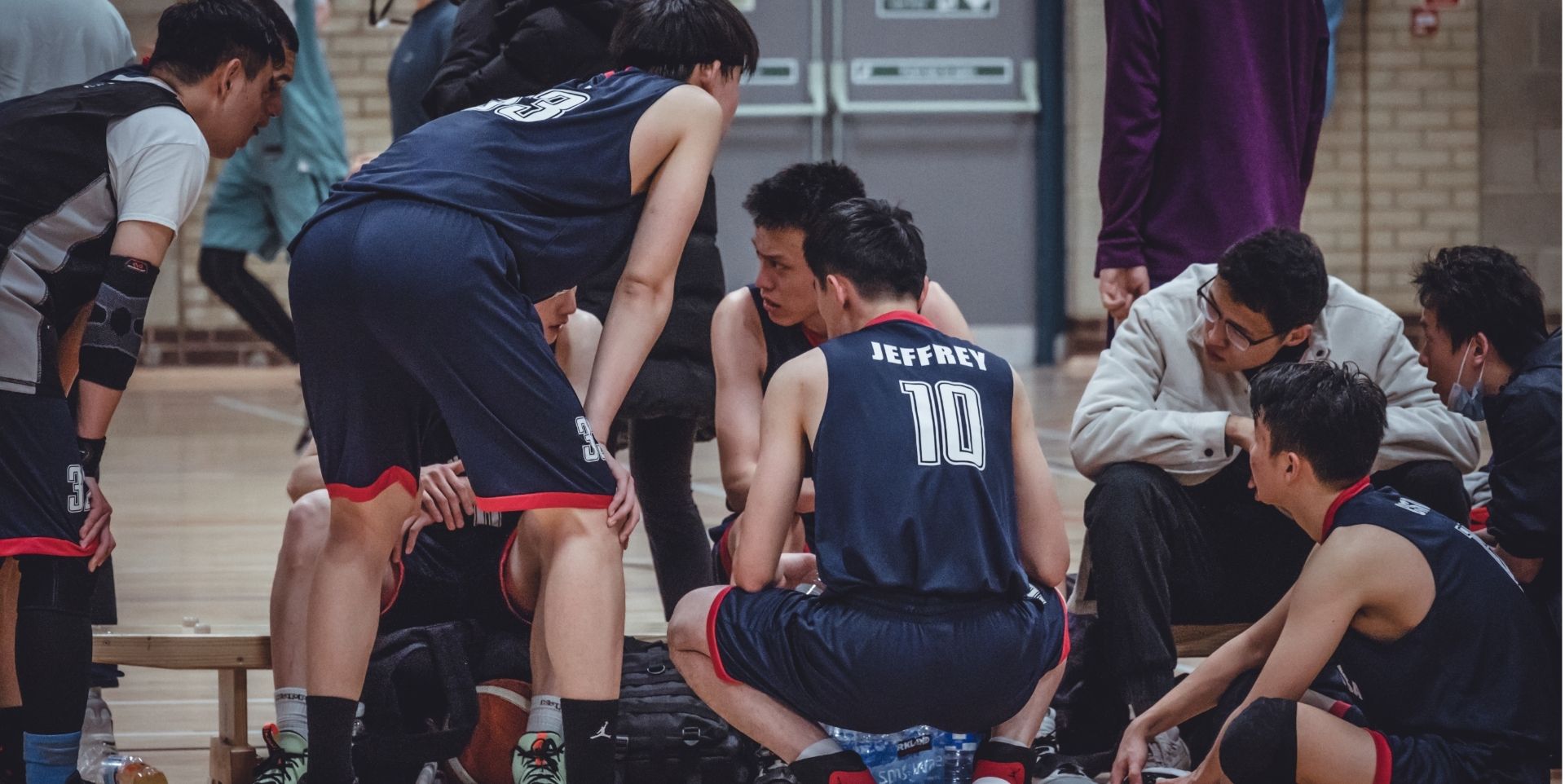 Basketball team huddled listening to their coach