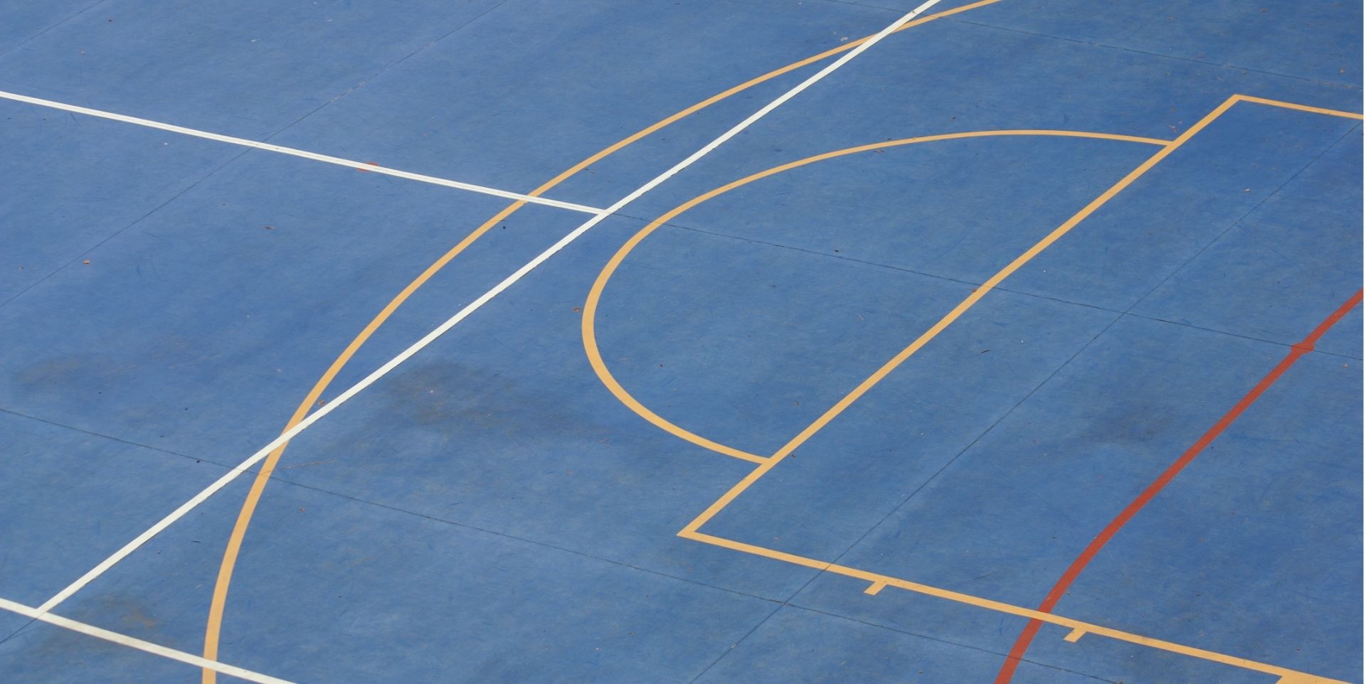Close-up of painted lines on a blue basketball court