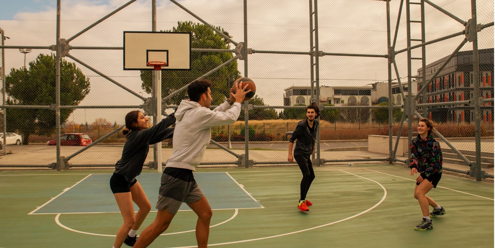 People playing basketball on outdoor court