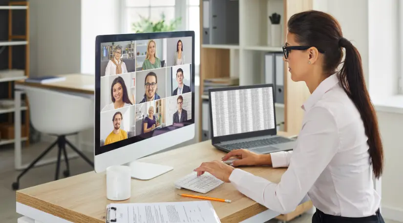 Woman on a video call with team at her desk