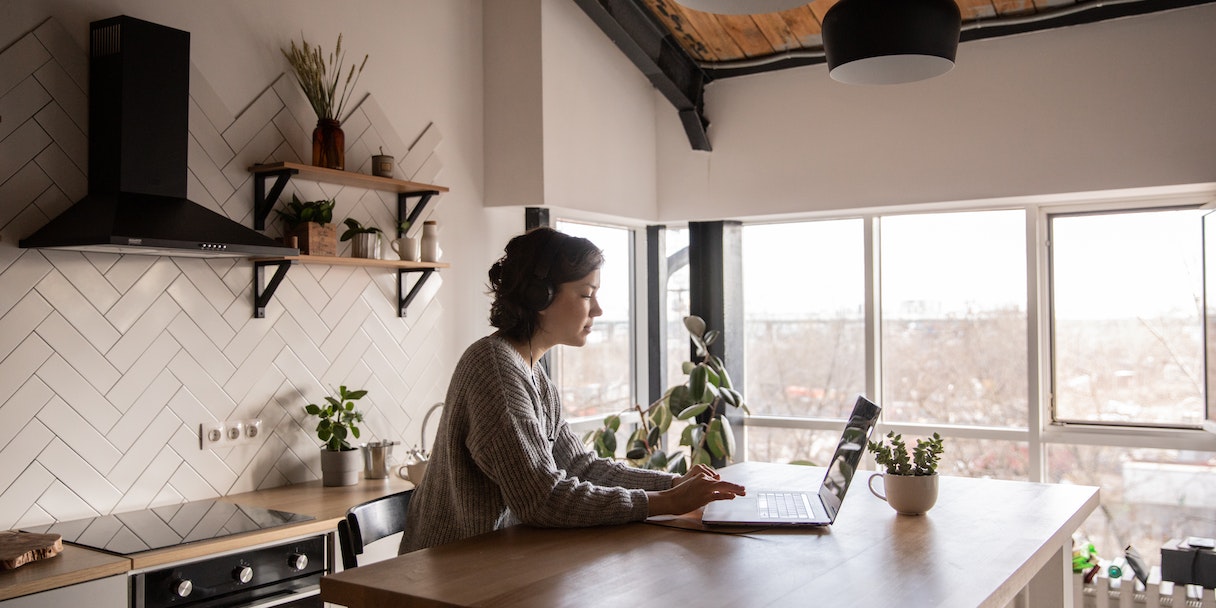 Woman working on a laptop in a kitchen