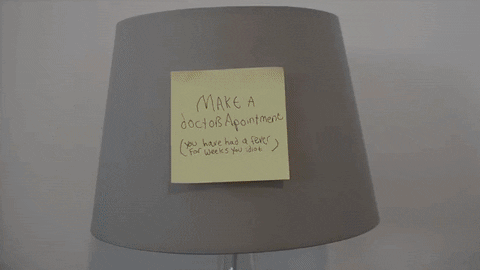 Sticky note reminder stuck on a lampshade