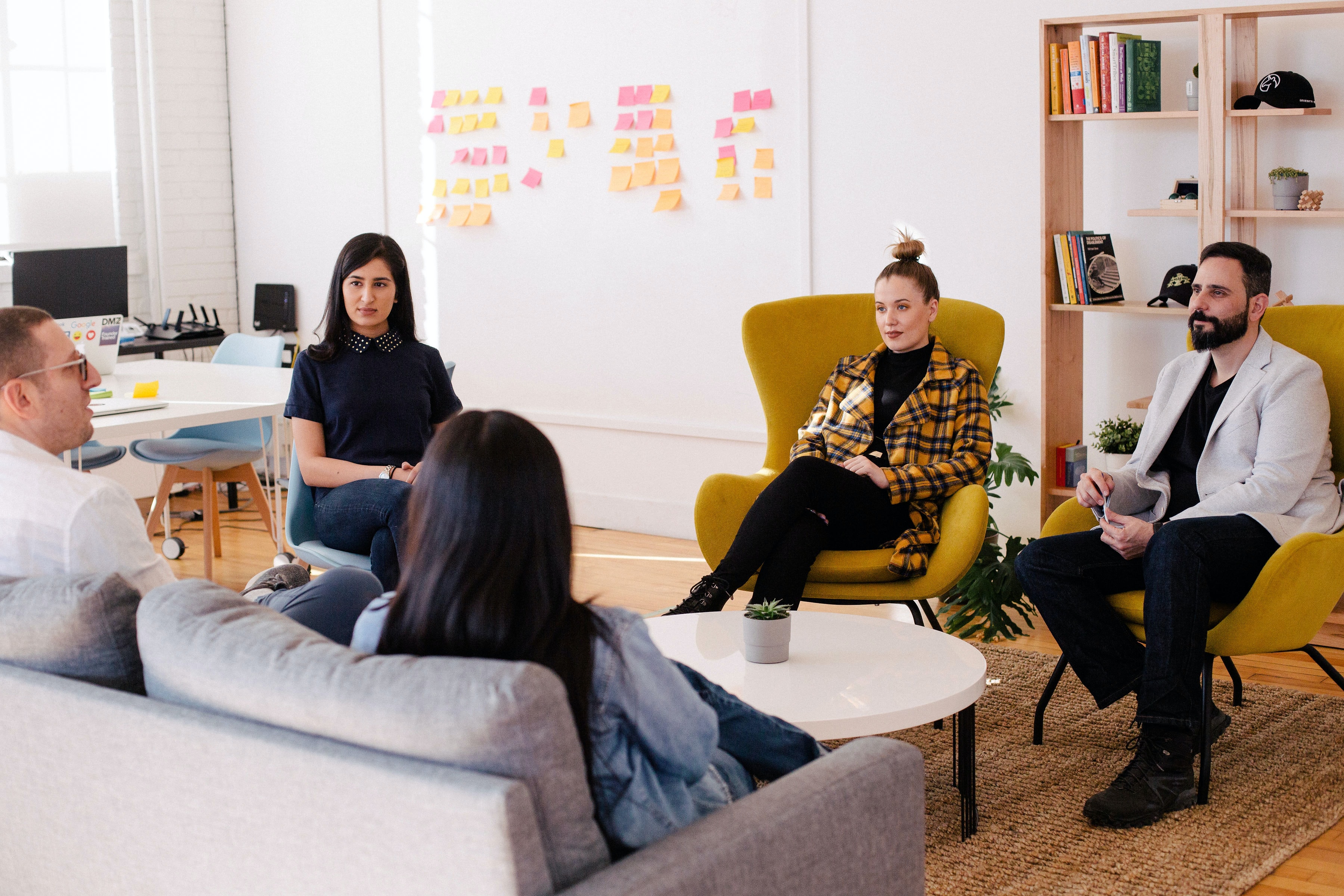 Team meeting in office with yellow armchairs