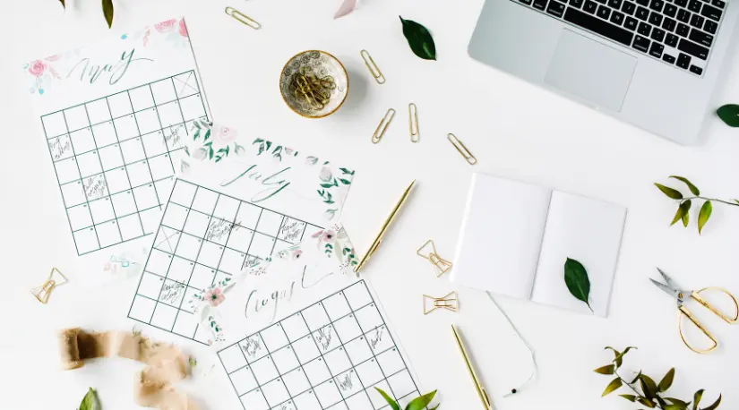 Flat lay of floral calendars and desk accessories