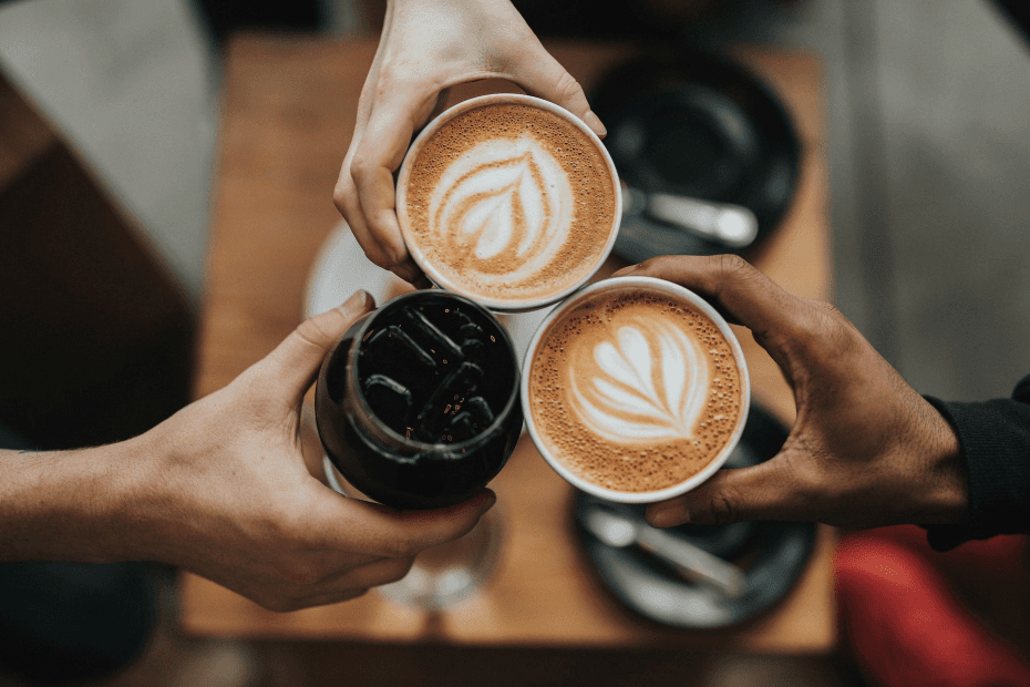 Three hands toasting with coffee cups