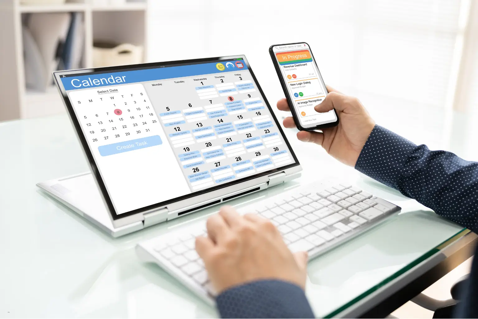 Hands using calendar apps on a laptop and phone