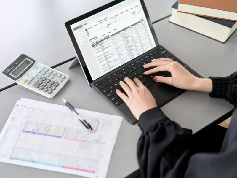 Open source scheduling for businesses shown on a tablet with spreadsheets and a calculator.