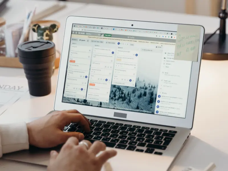 Team scheduling platforms displayed on a laptop screen with task cards organized by status.
