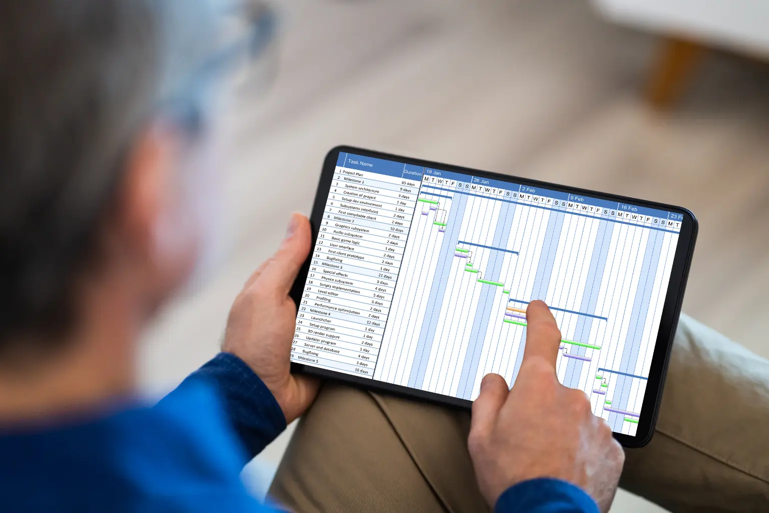 Man reviewing a project timeline chart on a tablet