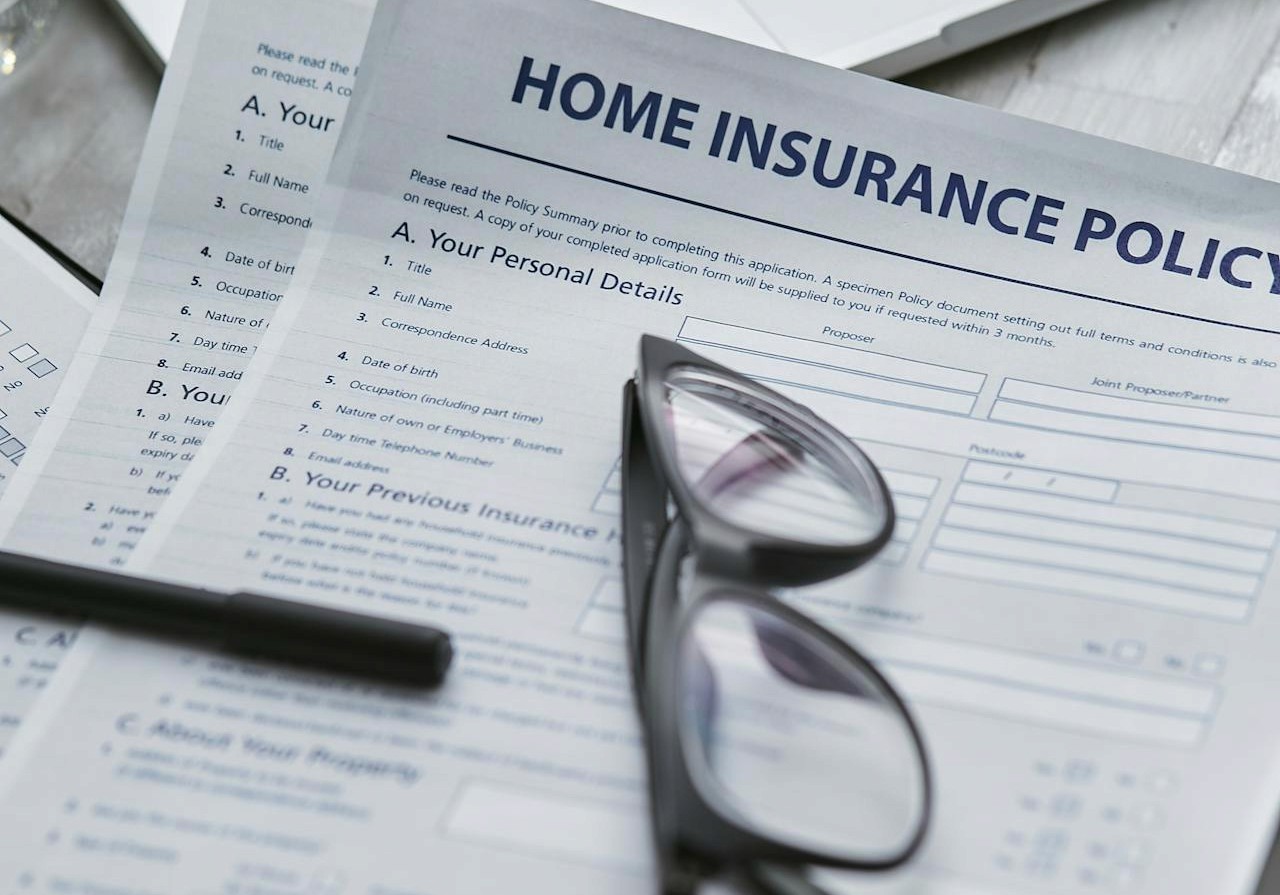 Home insurance policy paperwork with glasses on top