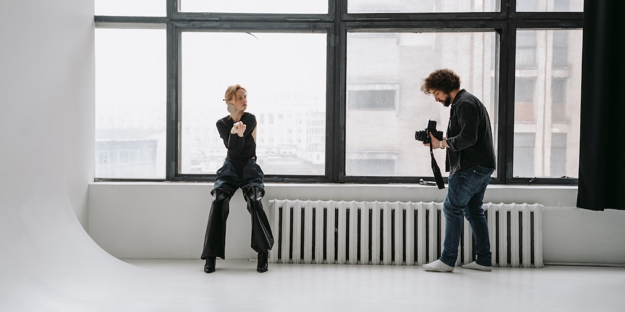 Photographer shooting a model in a studio