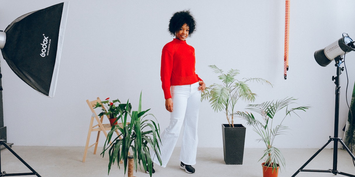 Woman posing in a photography studio with plants