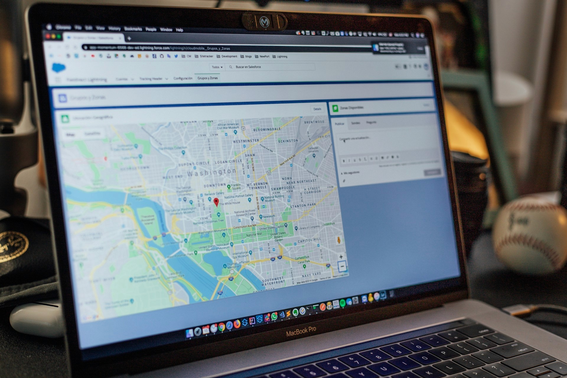 A MacBook Pro displaying a Salesforce dashboard with a map of Washington, D.C.