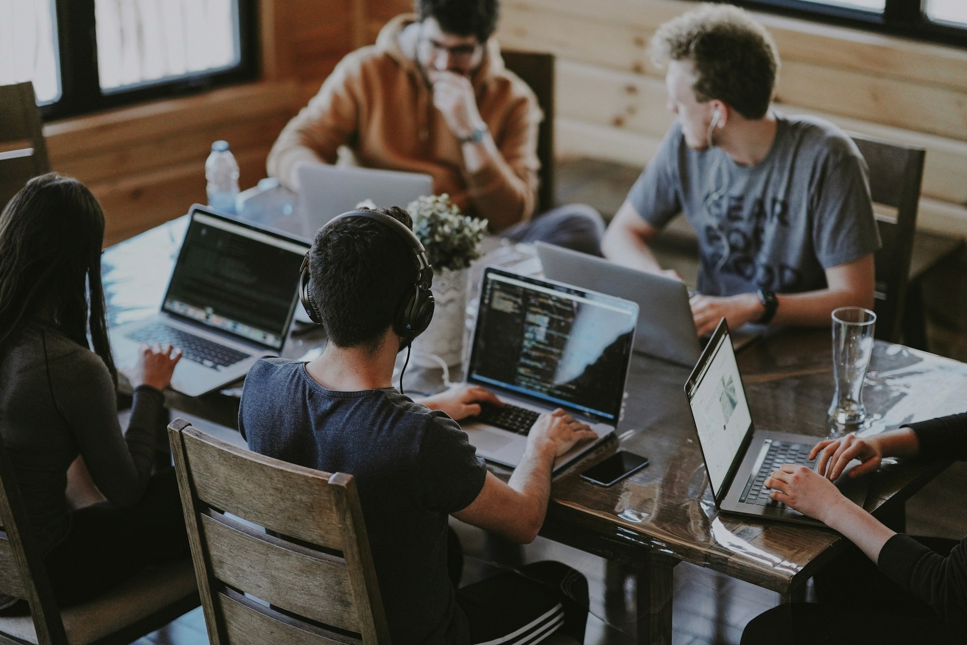 A technical team using laptops to build and manage complex backend workflows for enterprise scheduling tools.