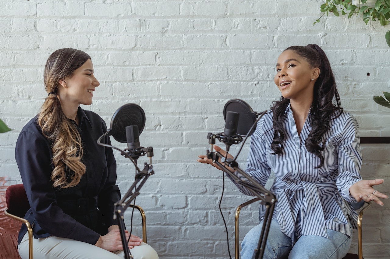 Two women recording a podcast with microphones