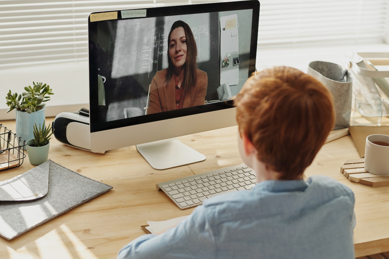 Child video calling a tutor onscreen