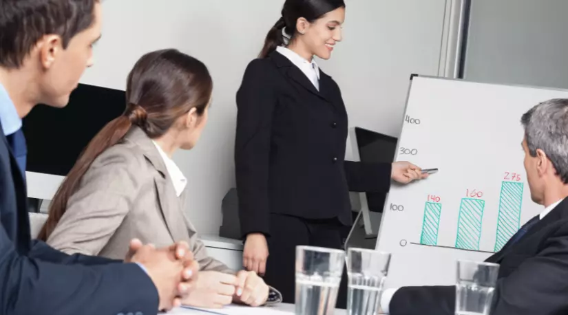 Presenter showing a bar chart to a business meeting