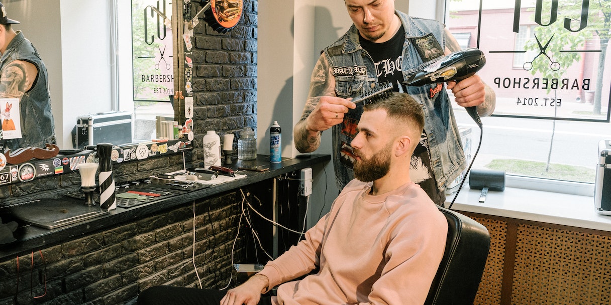 Barber styling a client's hair in a barbershop