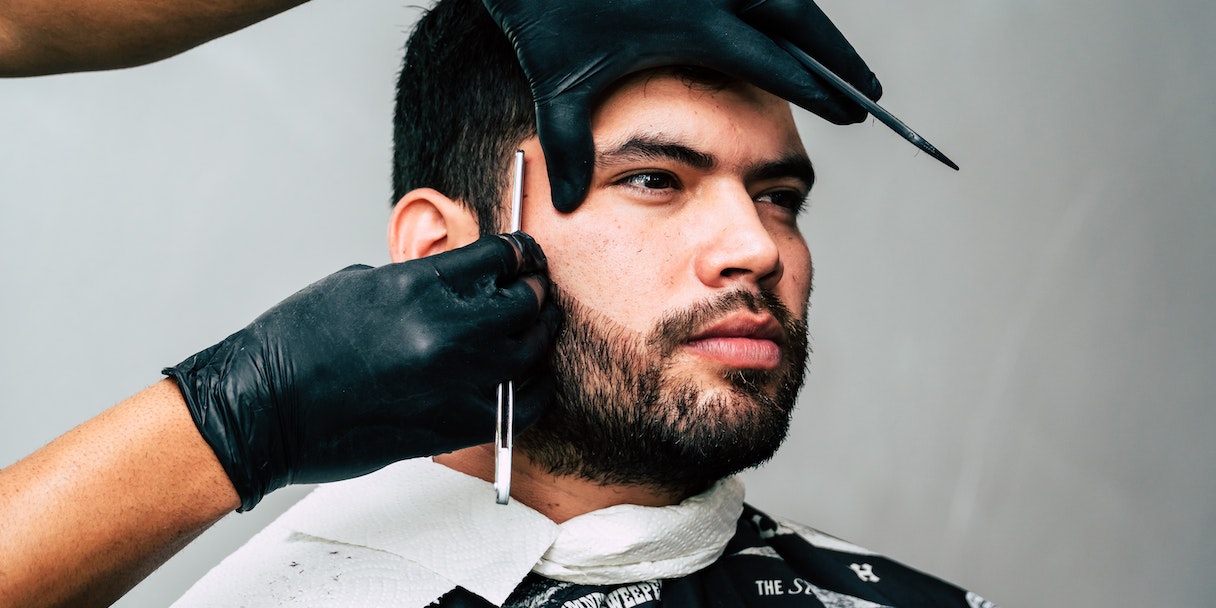 Barber giving a client a haircut with clippers