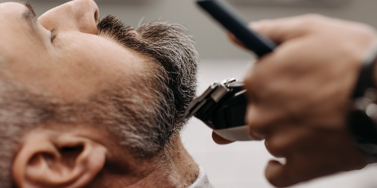 Barber trimming a client's beard