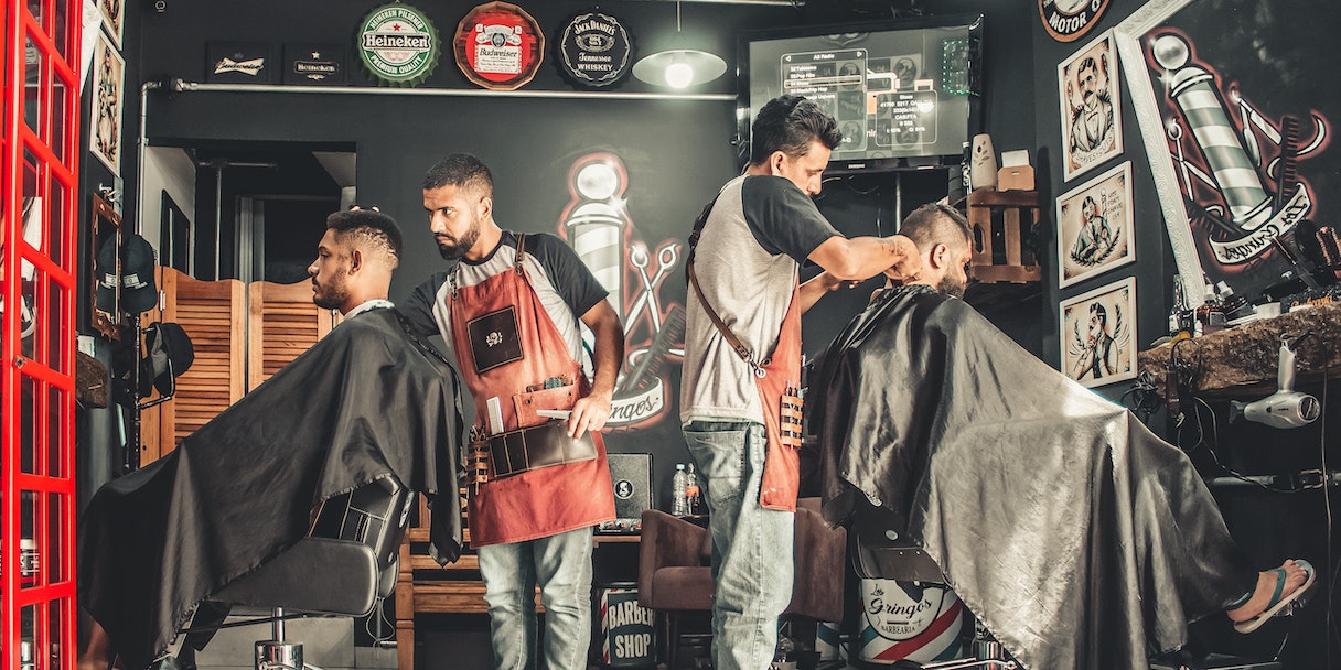 Barbers cutting hair with customers in a barbershop