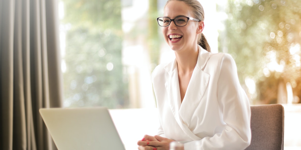 Woman laughing during a video call on a laptop