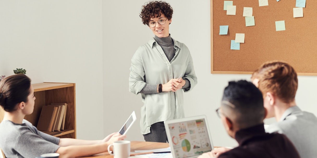 Woman presenting to colleagues in a meeting room