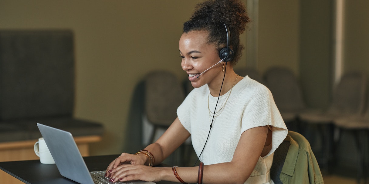 Woman with a headset working on a laptop