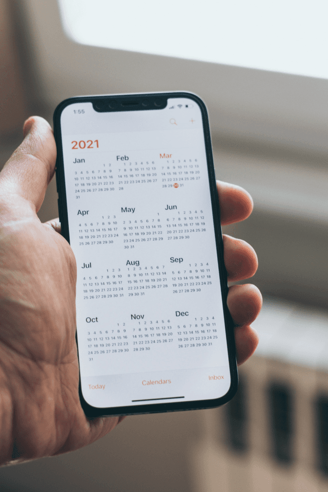Hand holding phone showing a calendar app