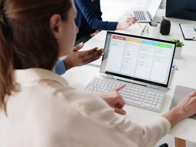 Best scheduler tool used by a team collaborating on a digital Kanban board on a 2-in-1 touchscreen device.