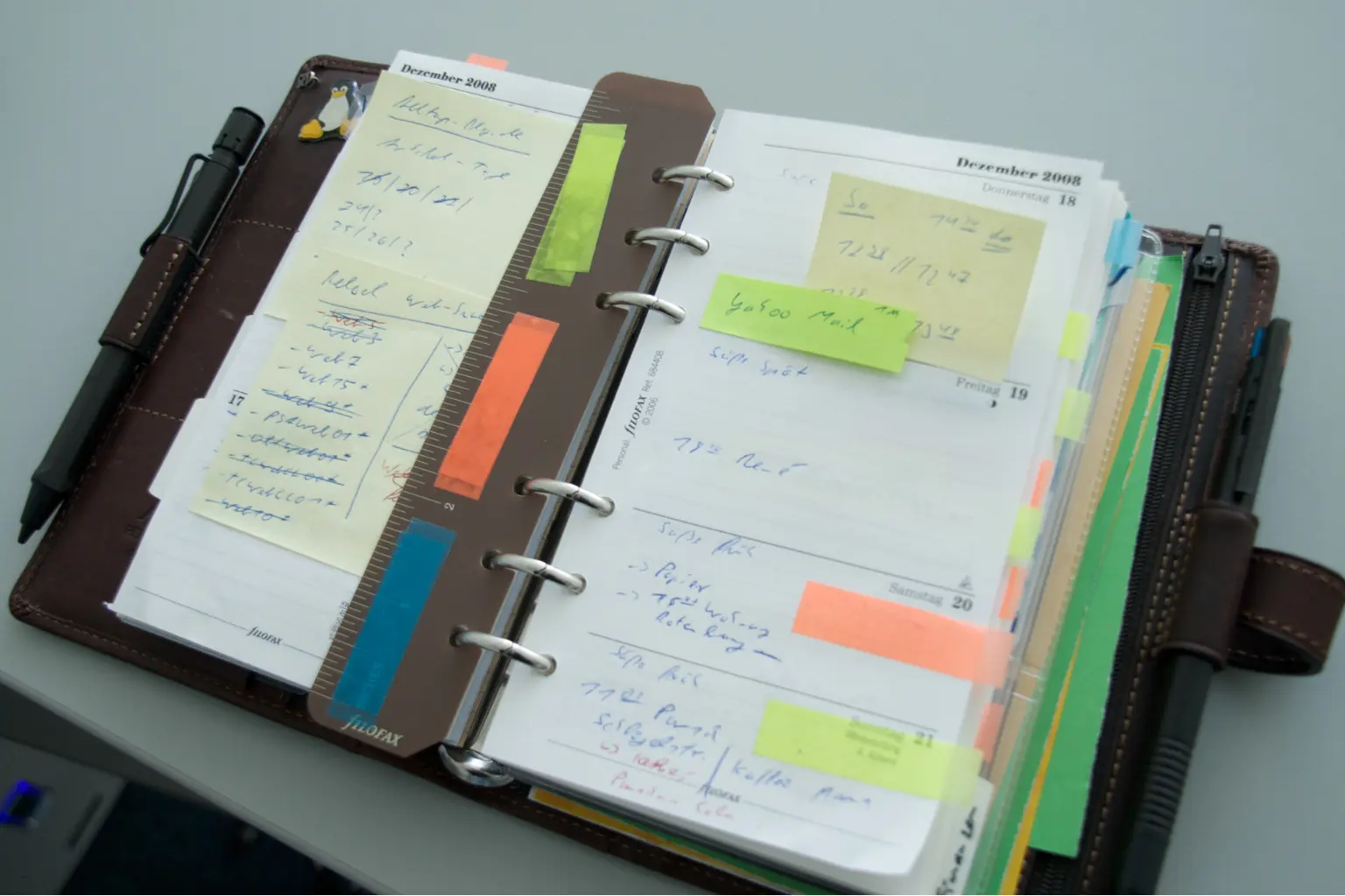 Leather planner filled with sticky notes and pen