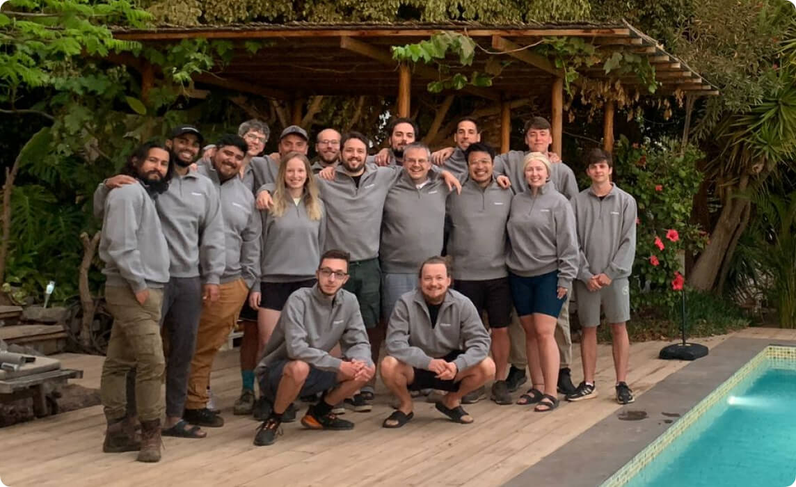 Cal.com team posing together by a pool