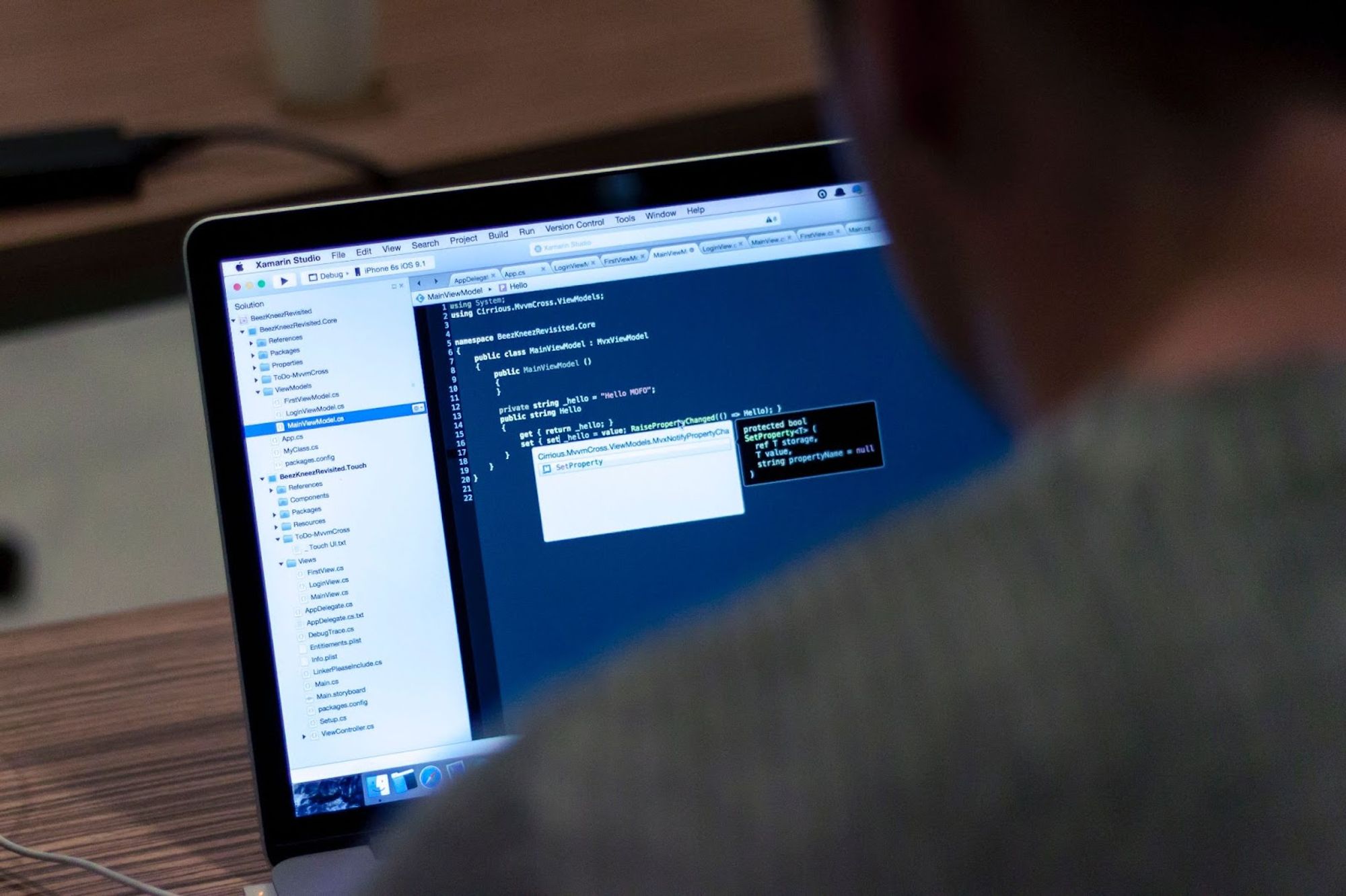 Person coding on a laptop with dark IDE theme
